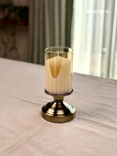 High Objects Luminaria Pedestal Candle Stand Set with tinted glass hurricane and antique brass stem, holding a cream pillar candle.
