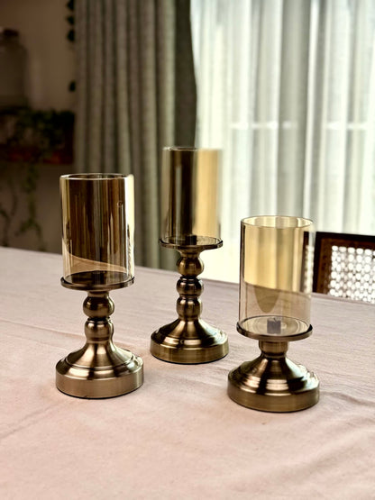 High Objects Luminaria Pedestal Candle Stand Set with bronze metallic stem and tinted glass hurricane holder.