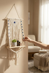 High Objects NazarGuard Boho Macrame Shelf with blue evil eye details, cotton ropes, and wooden shelf holding a plant and bottles.