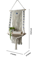 High Objects NazarGuard Boho Macrame Shelf with blue evil eye details, handmade cotton rope and wooden shelf holding books and a plant.