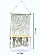 High Objects cream macramé shelf with diamond and chevron weaves, natural wood base, and hanging rope. 24" H x 16" W.