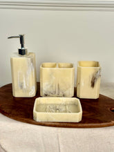 High Objects Marrow Stone Bathroom Accessory Set: lotion dispenser, toothbrush holder, cup, and soap dish in cream with grey marbling.