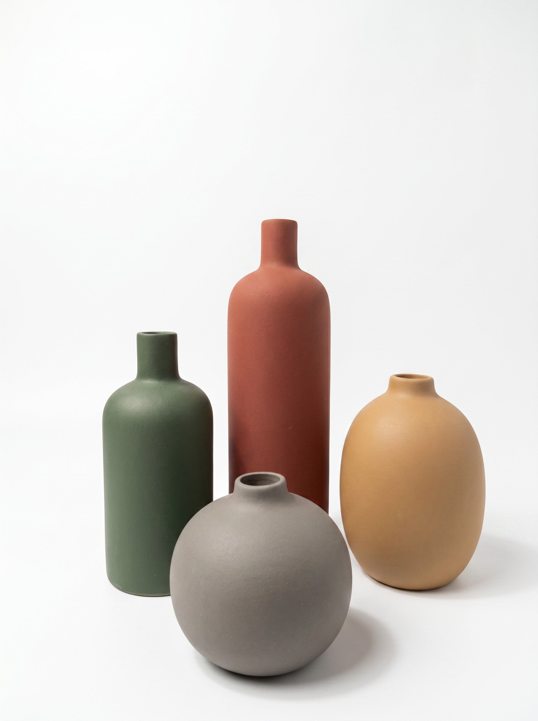 High Objects set of four matte ceramic vases in green, rust, grey, and tan. Various shapes and sizes.