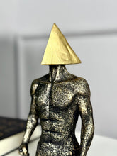 High Objects abstract sculpture of a muscular torso with a gold triangle head, textured stone-like finish.