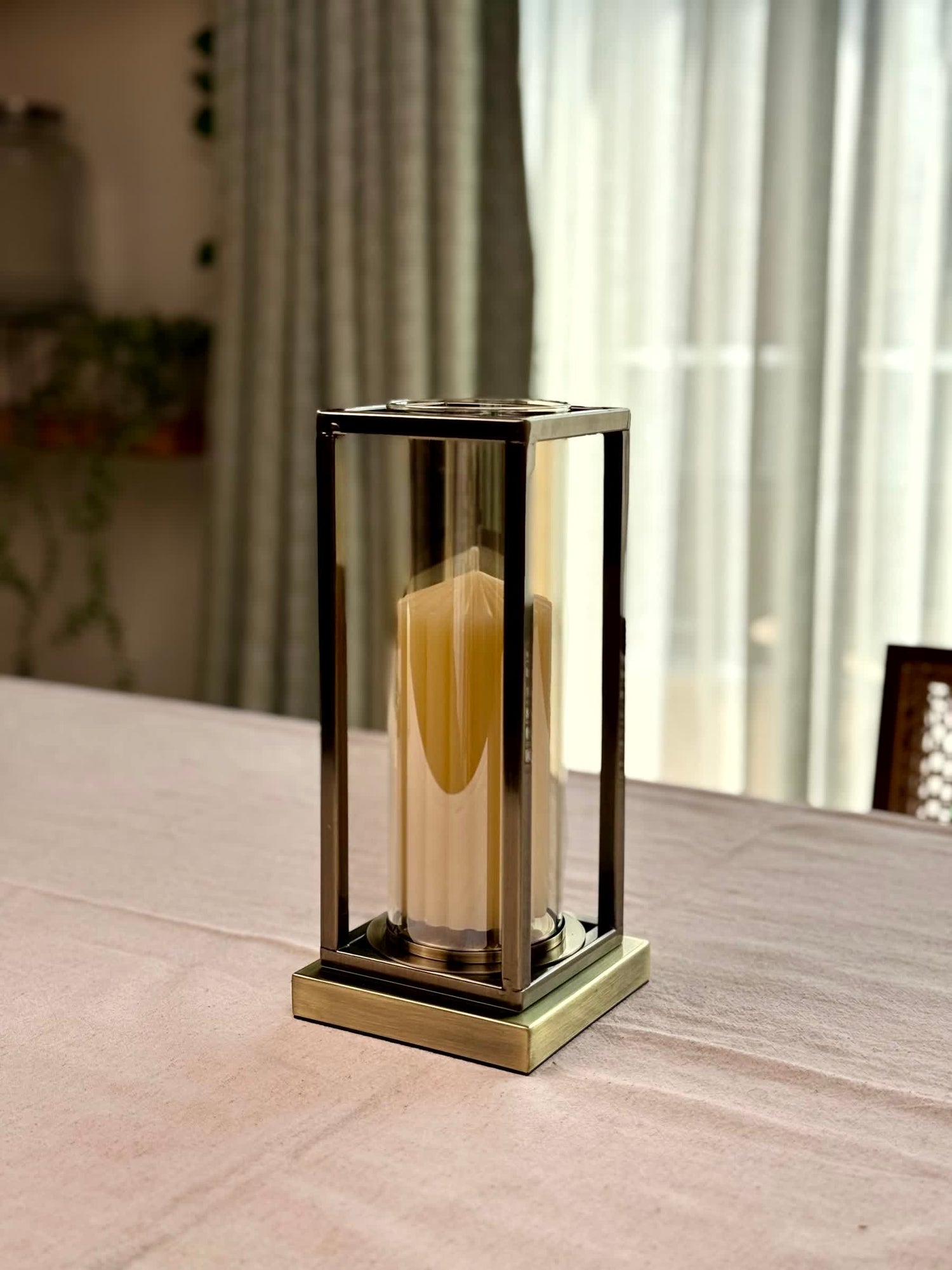 High Objects Modern Halo Frame Candle Stand Set, bronze metal frame with glass cylinder holding a cream candle.