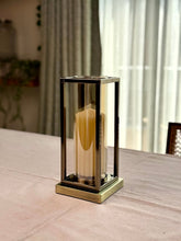 High Objects Modern Halo Frame Candle Stand Set, bronze metal frame with glass cylinder holding a cream candle.
