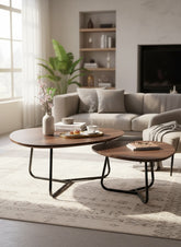 High Objects modern round nesting coffee table set with dark wood tops and black metal bases. One table holds a tray with pastries and coffee.