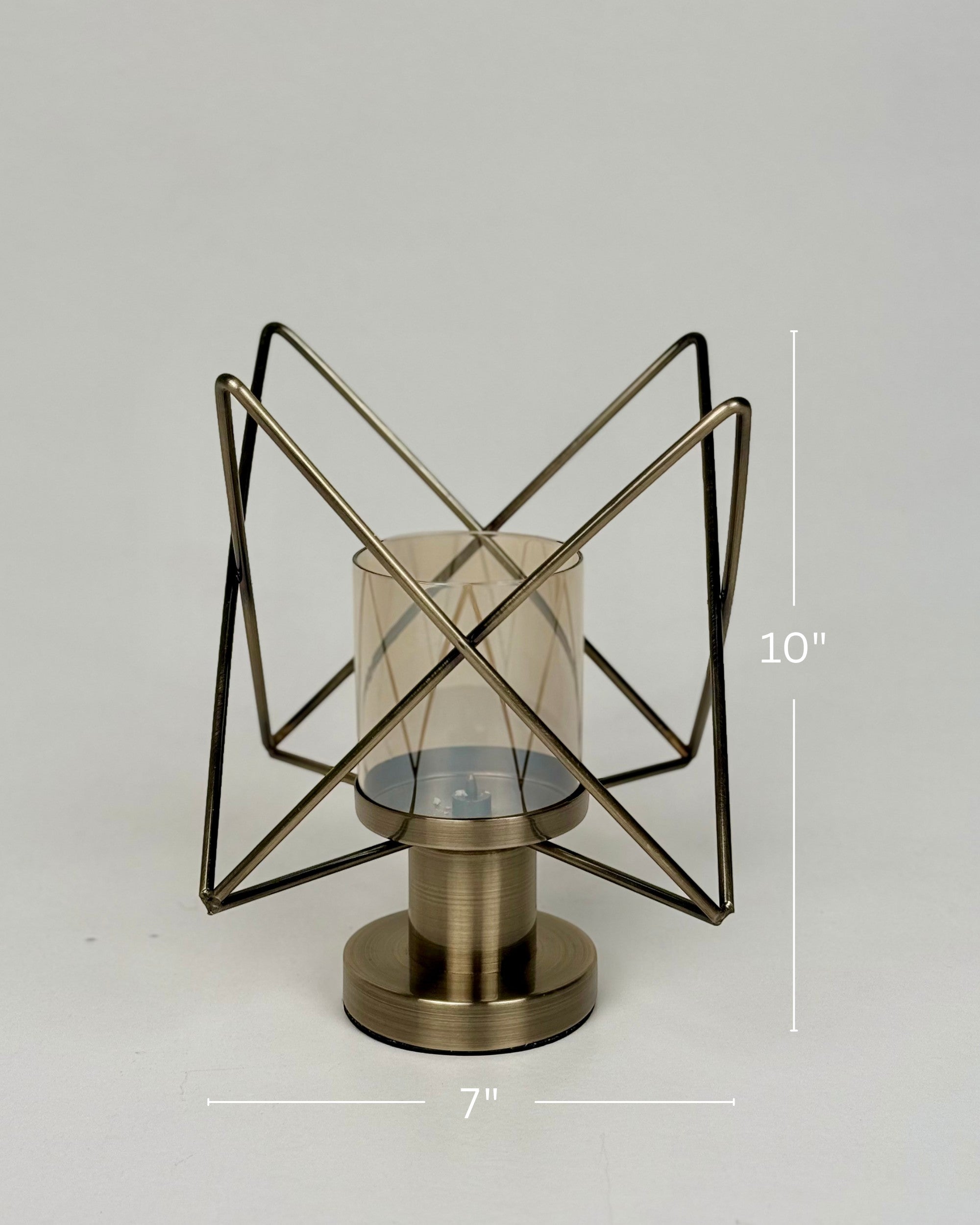 High Objects Nexus Geo Candle Stand, modern geometric metal frame with amber glass cylinder, antique brass finish.