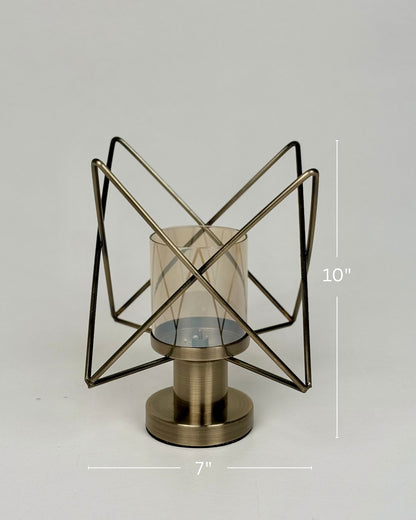 High Objects Nexus Geo Candle Stand, modern geometric metal frame with amber glass cylinder, antique brass finish.