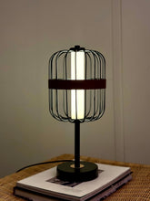 High Objects Noir Ember Cage Table Lamp with matte black wire cage, red leather accent, and gold detailing.