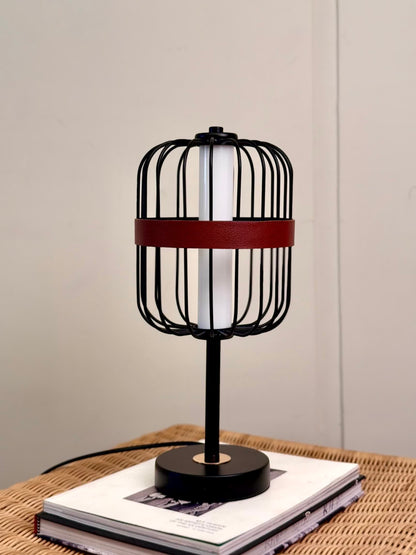 High Objects Noir Ember Cage Table Lamp with black wire cage, red leather band, and gold base detail.