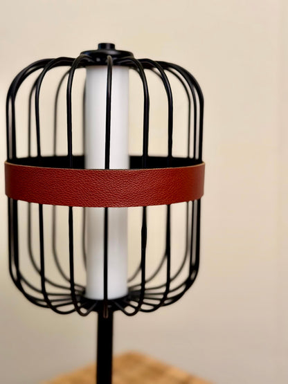 High Objects Noir Ember Cage Table Lamp with black wire cage, red leather band, and gold accents.