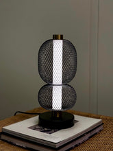 High Objects Nova Mesh Duo Table Lamp with black mesh spheres and brushed gold accents, emitting a soft glow.