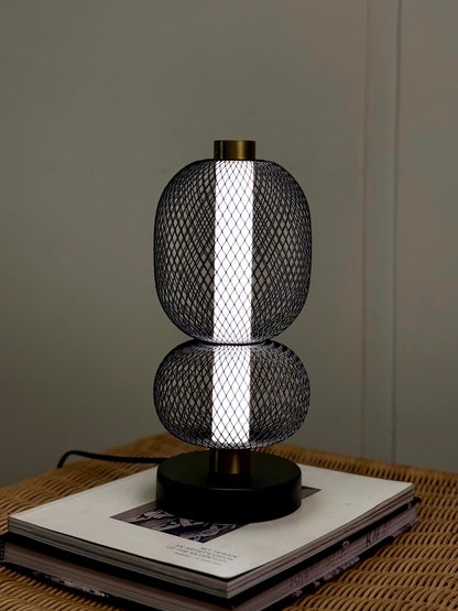 High Objects Nova Mesh Duo Table Lamp with black mesh spheres and brushed gold accents, emitting a soft glow.