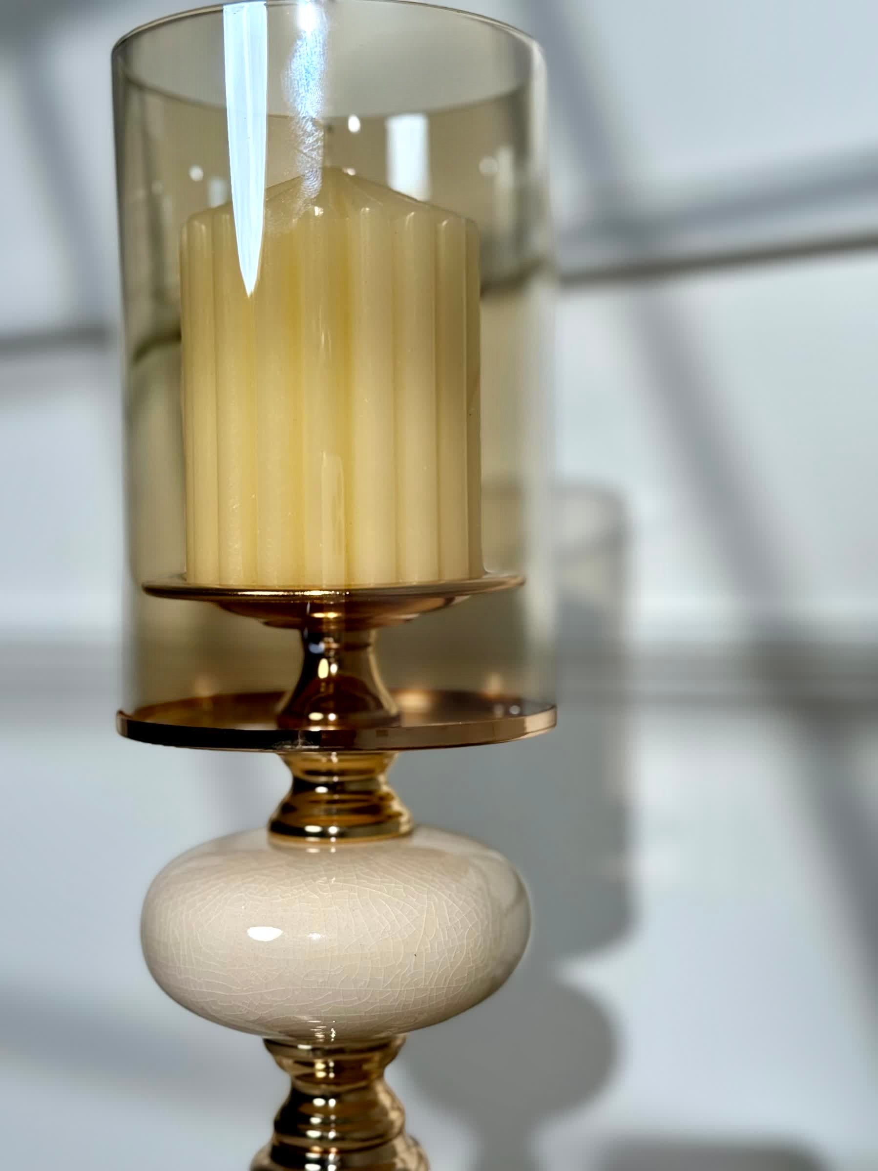 High Objects Opaline Gold Candle Stand Collection with amber glass hurricane shade and cream ceramic accent.