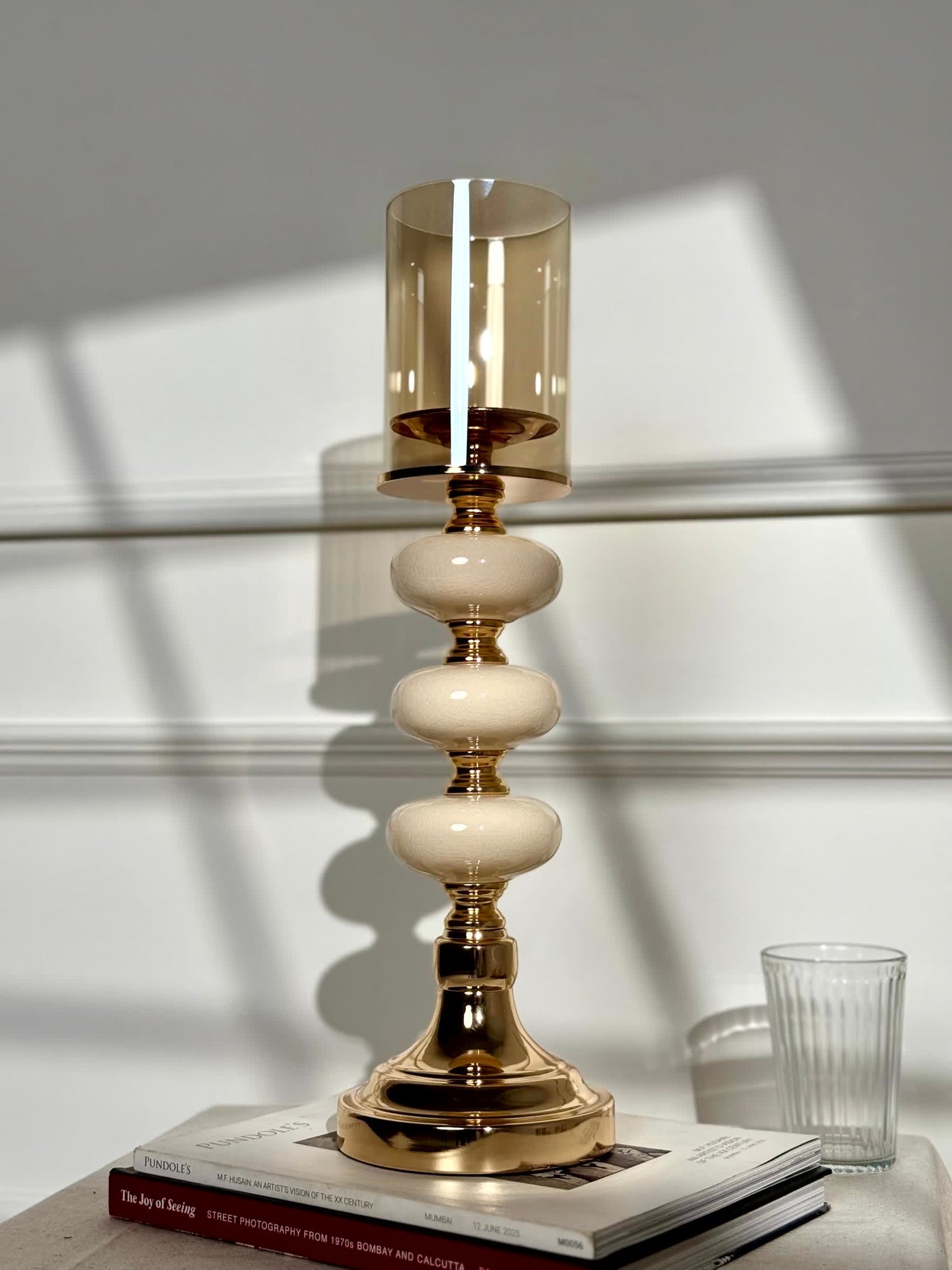 High Objects Opaline Gold Candle Stand Collection with amber glass hurricane shade and stacked opaline accents.