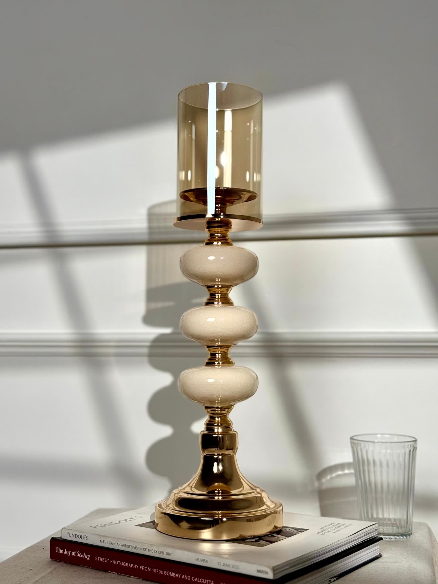 High Objects Opaline Gold Candle Stand Collection with amber glass hurricane shade and stacked opaline accents.