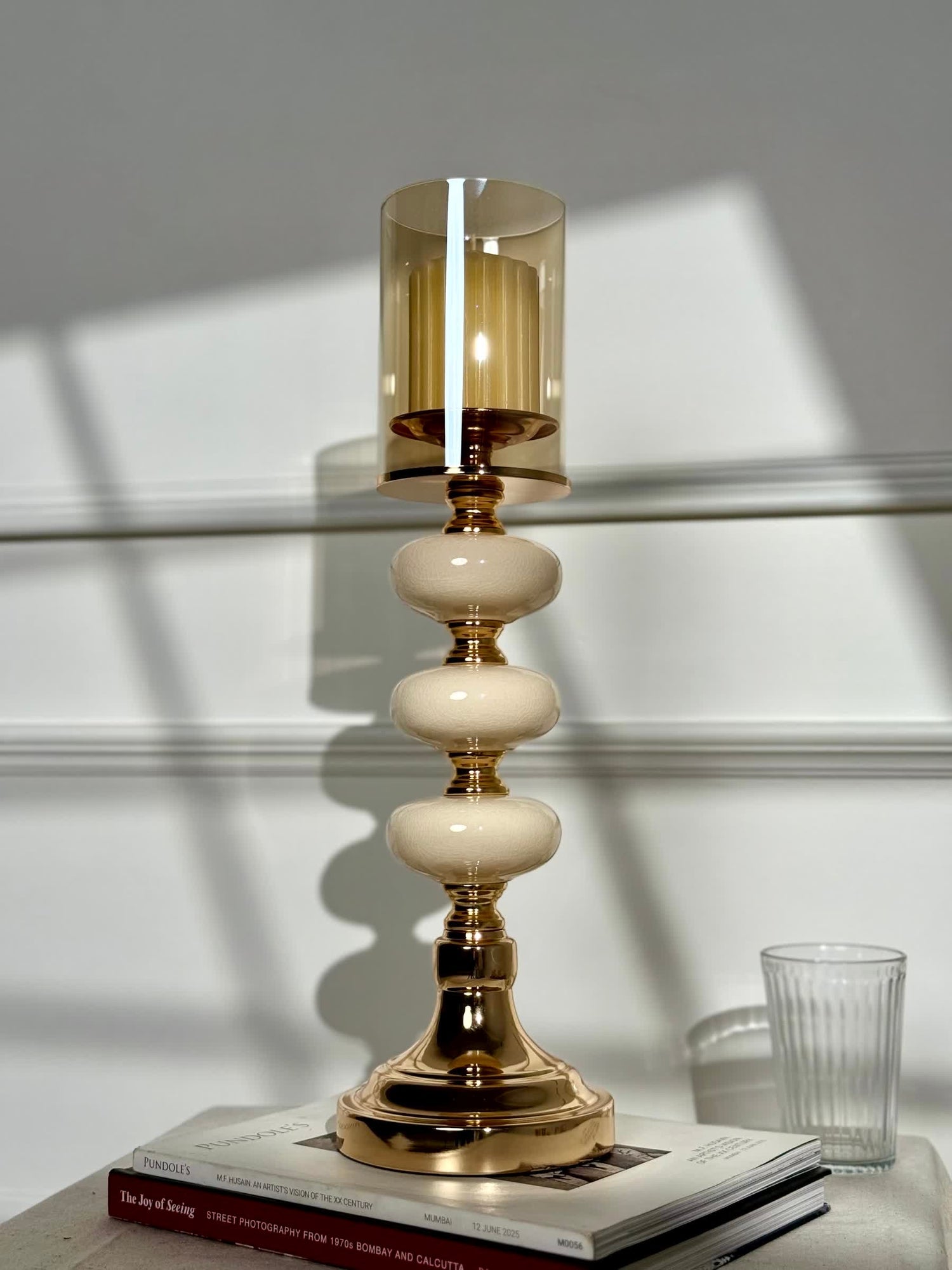 High Objects Opaline Gold Candle Stand Collection with amber glass hurricane shade and stacked opaline accents.