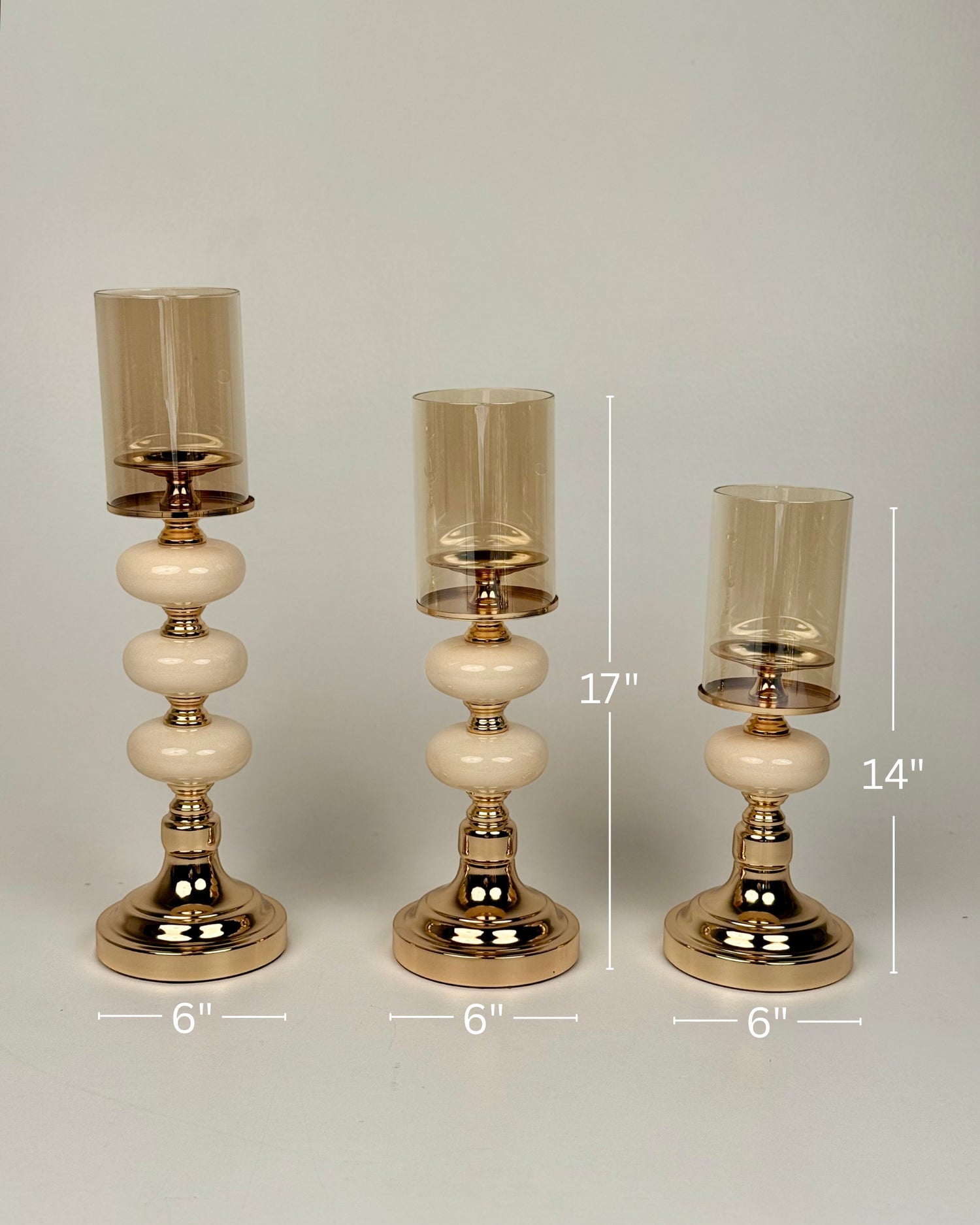 High Objects Opaline Gold Candle Stand Collection set of 3, featuring gold bases, opaline accents, and amber glass shades in varying heights.