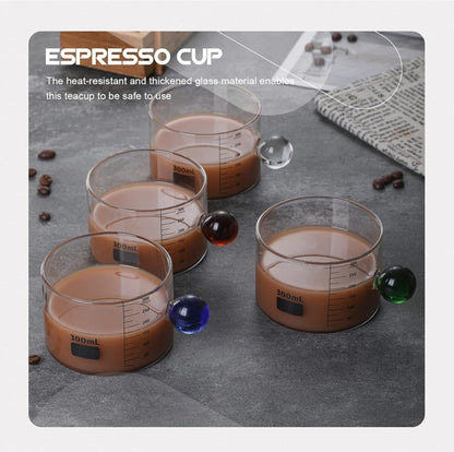High Objects Orb Glass Cup Set with unique orb handles in green, red, blue, and clear. 300ml borosilicate glass cups with measurement markings.