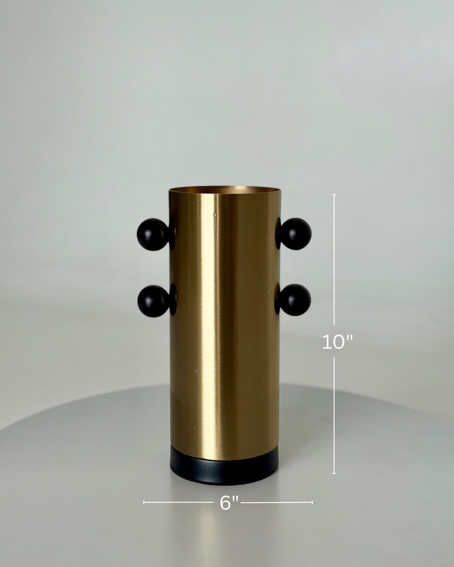 High Objects Orbis Luxe cylindrical gold vase with black orb accents, 10" H x 6" W.