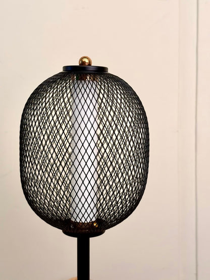 High Objects Orion black mesh pedestal table lamp with gold accent and white cylindrical shade.