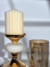 High Objects Pebble Luxe candle stand set with a cream pillar candle and amber glass hurricane.