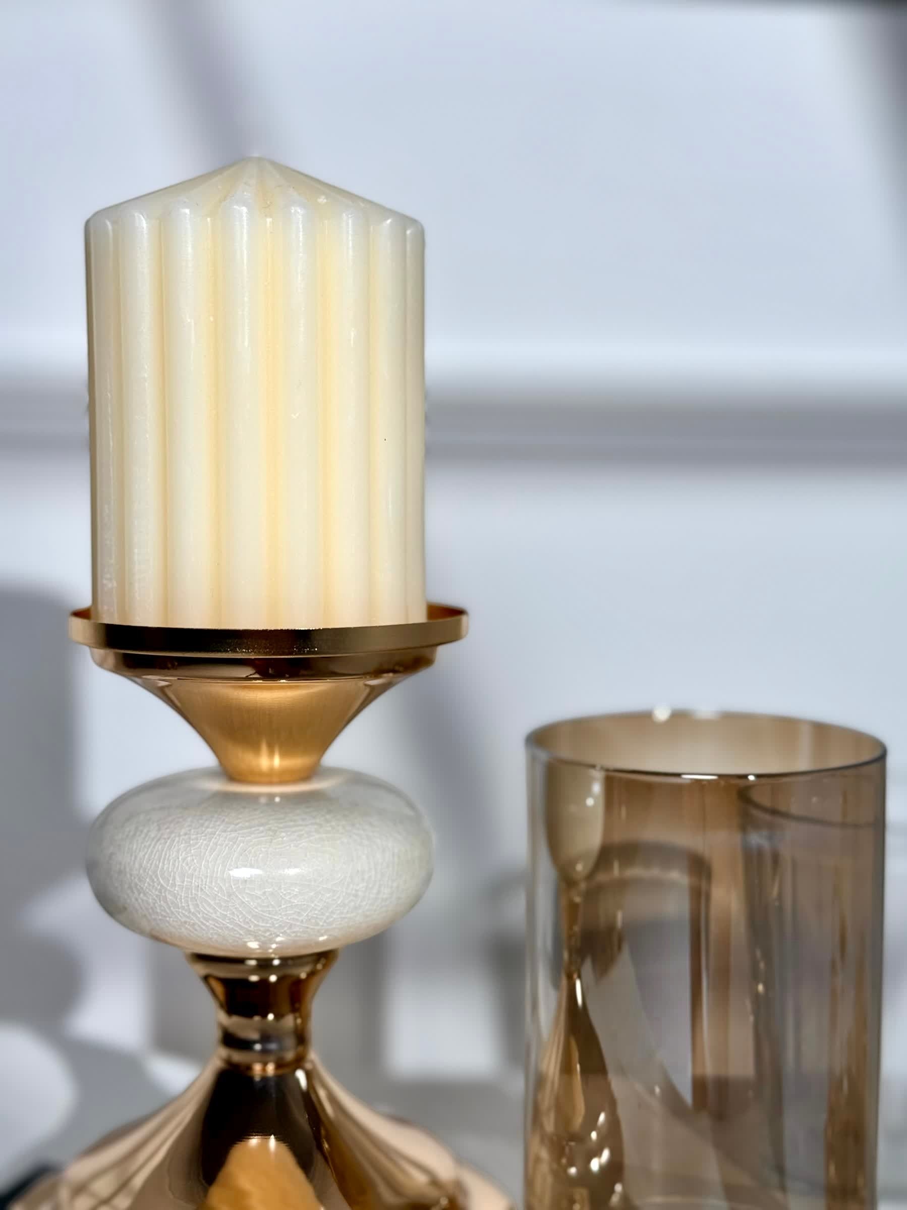 High Objects Pebble Luxe candle stand set with a cream pillar candle and amber glass hurricane.