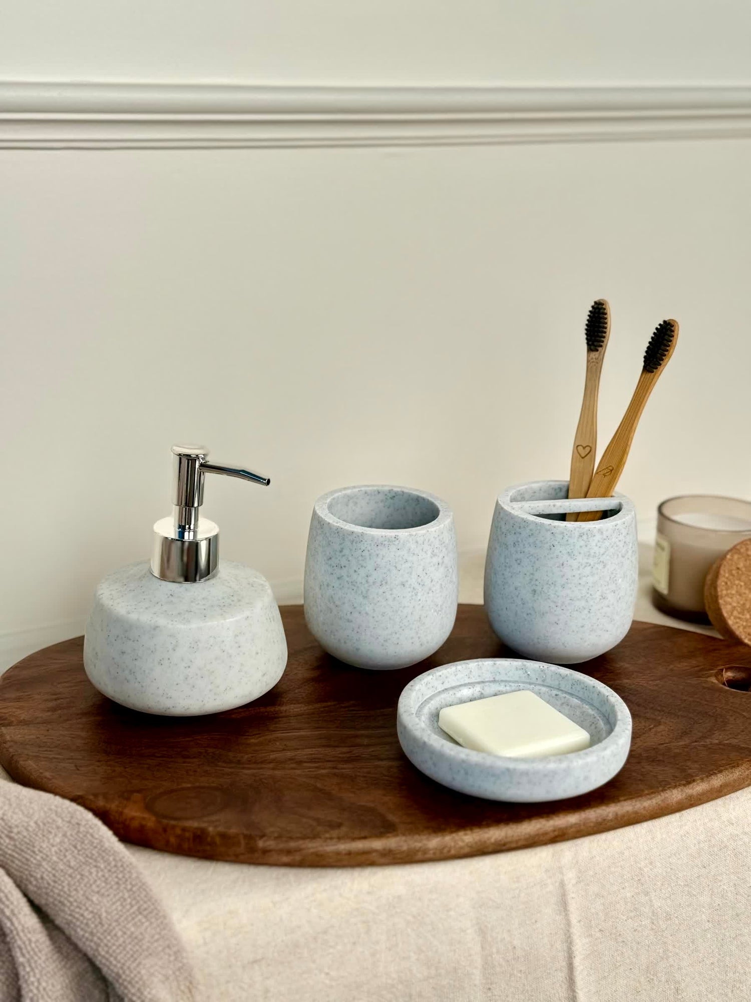 High Objects Pebbleease bathroom accessory set with soap dispenser, toothbrush holder, and soap dish in speckled light blue.