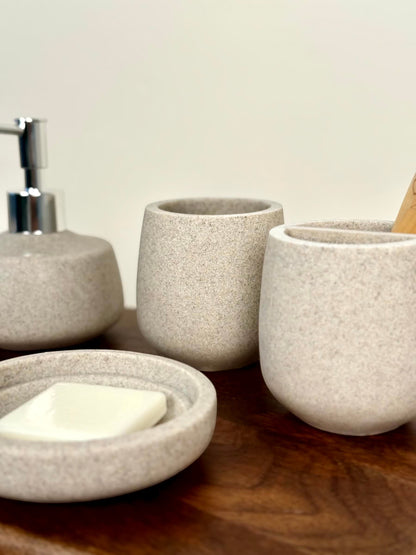 High Objects Pebbleease speckled stone bathroom accessory set with soap dish, soap dispenser, and toothbrush holder.
