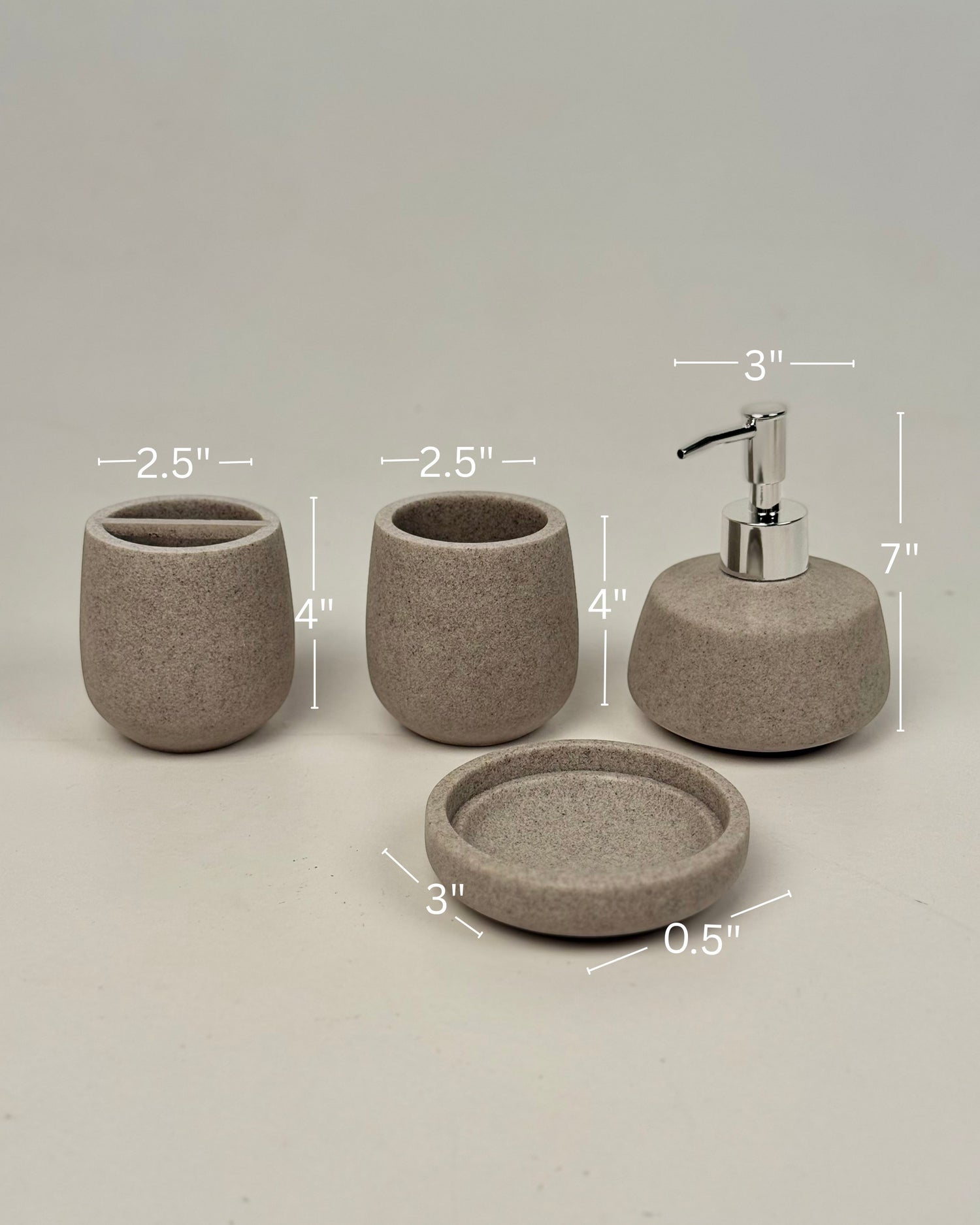High Objects Pebbleease Bathroom Accessory Set in speckled taupe resin. Includes soap dispenser, toothbrush holder, cup, and dish.