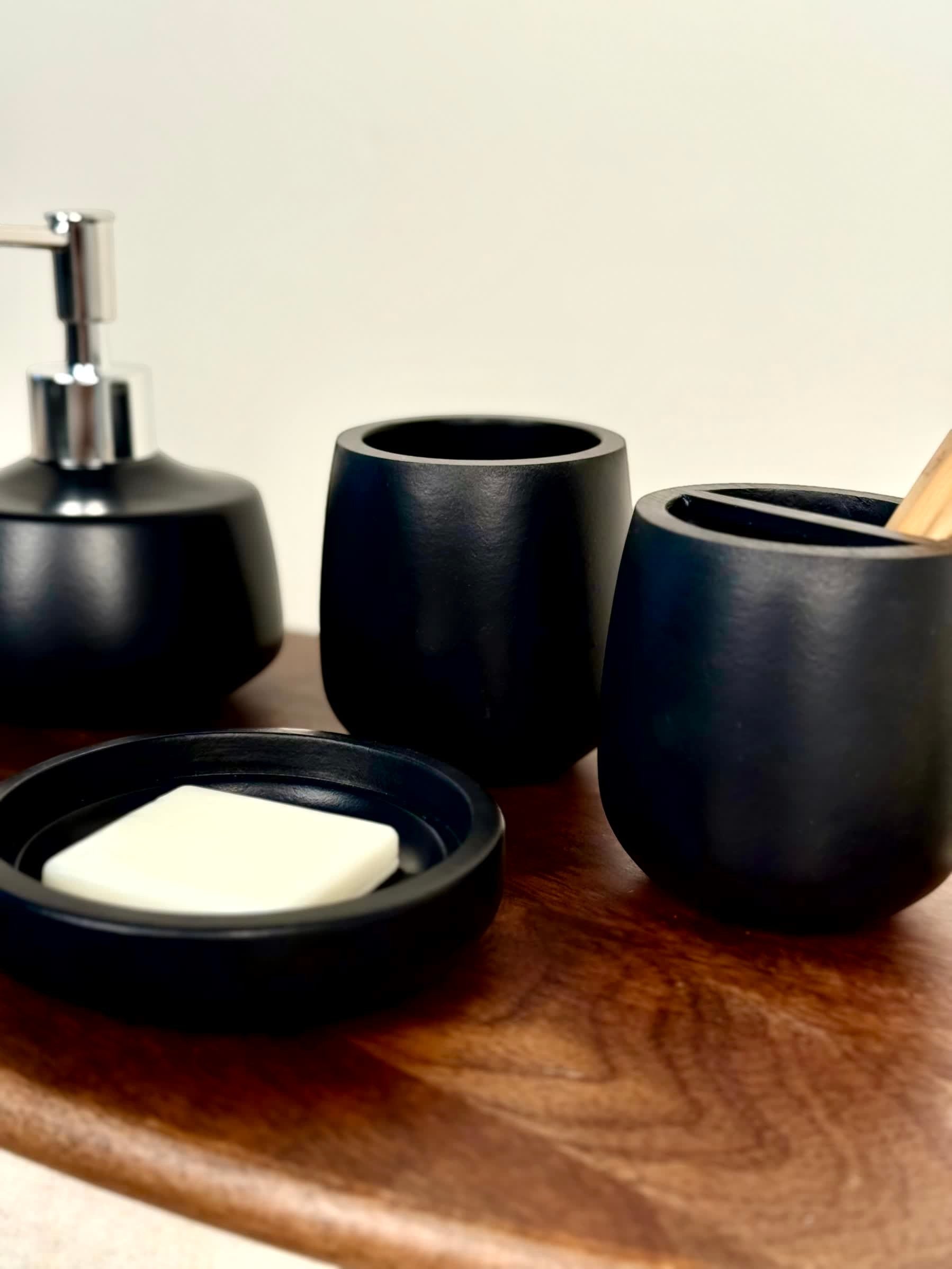 High Objects Pebbleease black bathroom accessory set with soap dish, dispenser, and tumbler.
