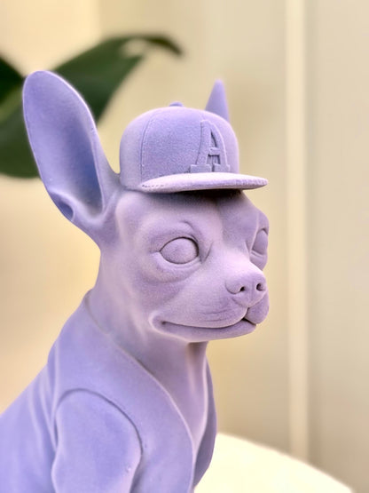 High Objects Pup City Showpiece, a matte lavender French bulldog sculpture wearing a baseball cap with an A logo.