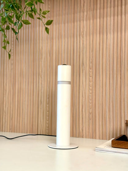 High Objects Pureline Column Table Lamp, white cylindrical minimalist lamp with a grey band detail, providing soft ambient light.