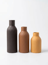 High Objects set of 3 ribbed ceramic vases in black, mustard yellow, and brown.