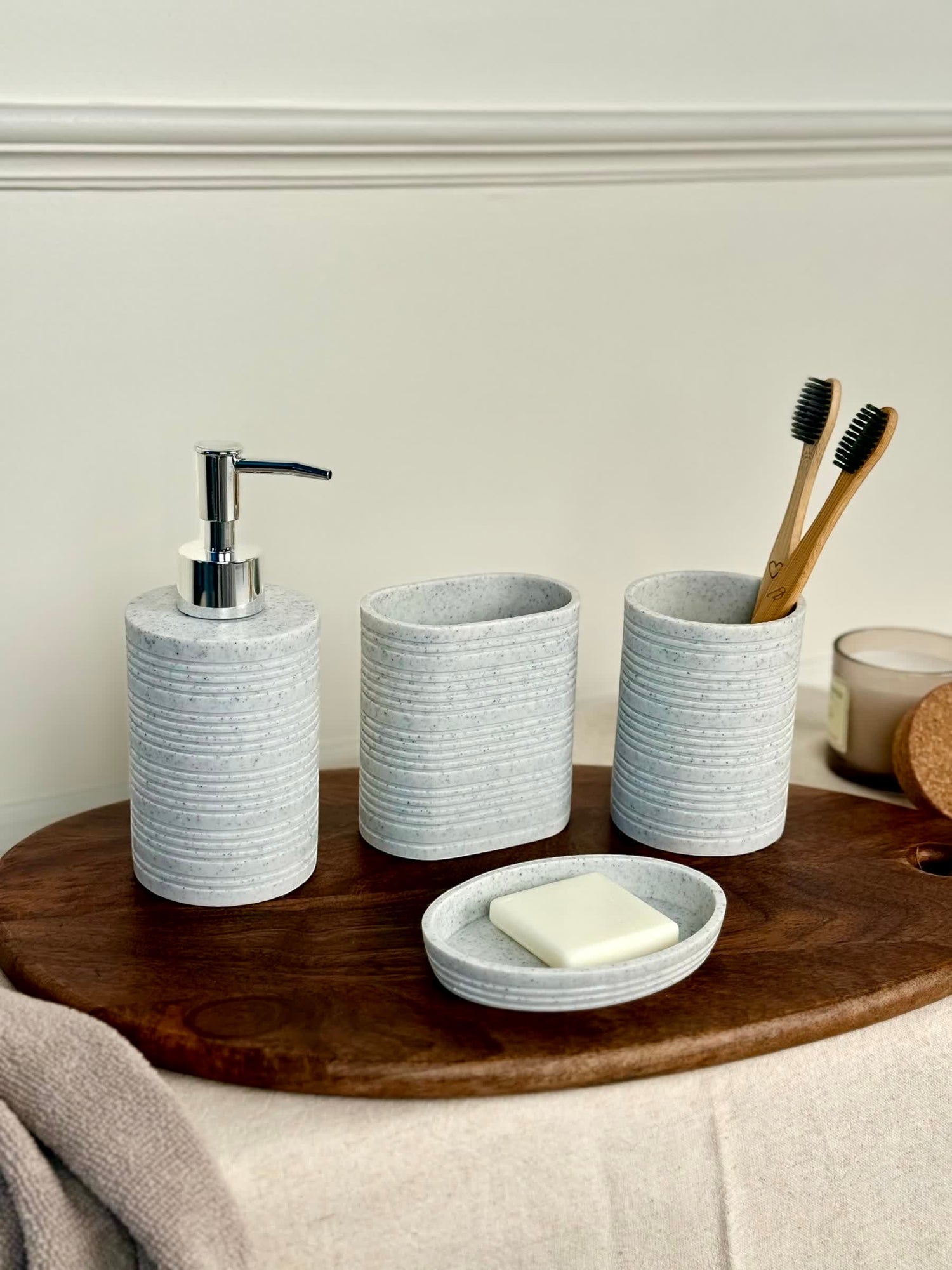 High Objects Ridgeline Bathroom Accessory Set: speckled grey soap dispenser, oval holder, toothbrush cup, and soap dish with horizontal ridges.