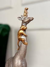 High Objects Savannah Majesty Showpiece sculpture of a giraffe with a monkey climbing its neck and a small animal on its head. Polyresin, dark finish.