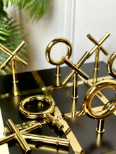 High Objects Sculpted Gold Tic-Tac-Toe Set with gold-finished iron X and O pieces on a black and gold board.
