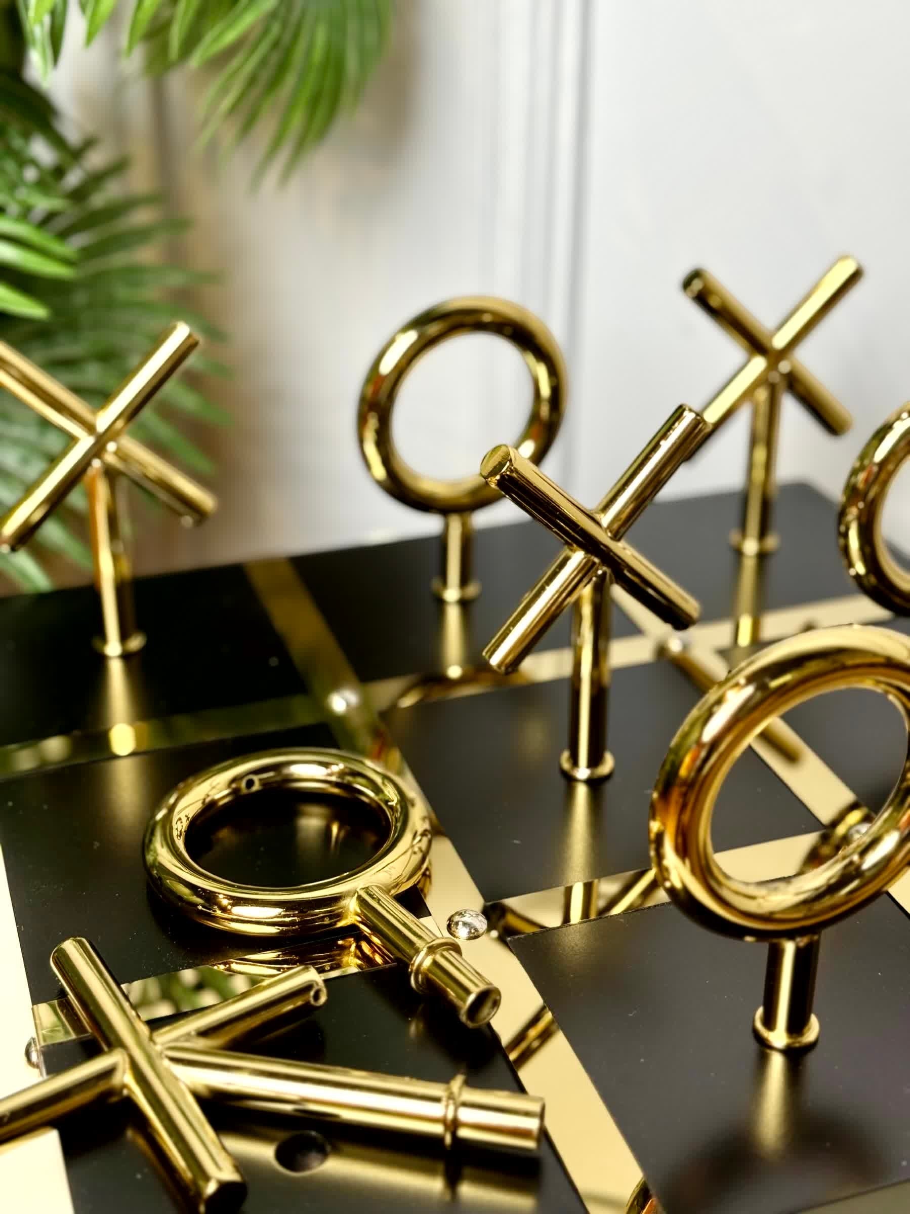 High Objects Sculpted Gold Tic-Tac-Toe Set with gold-finished iron X and O pieces on a black and gold board.