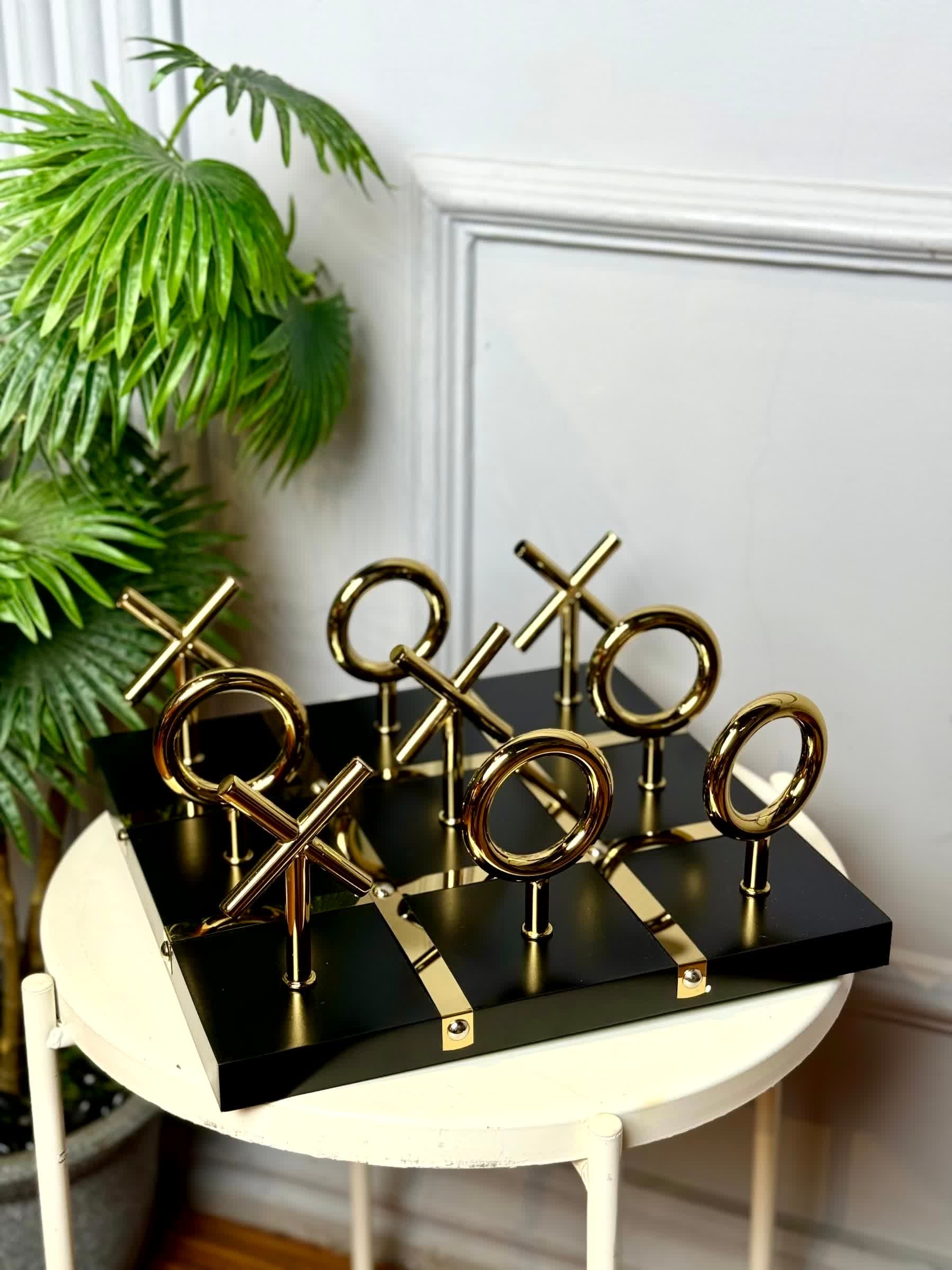 High Objects Sculpted Gold Tic-Tac-Toe Set with gold-finished iron X and O pieces on a black MDF board.