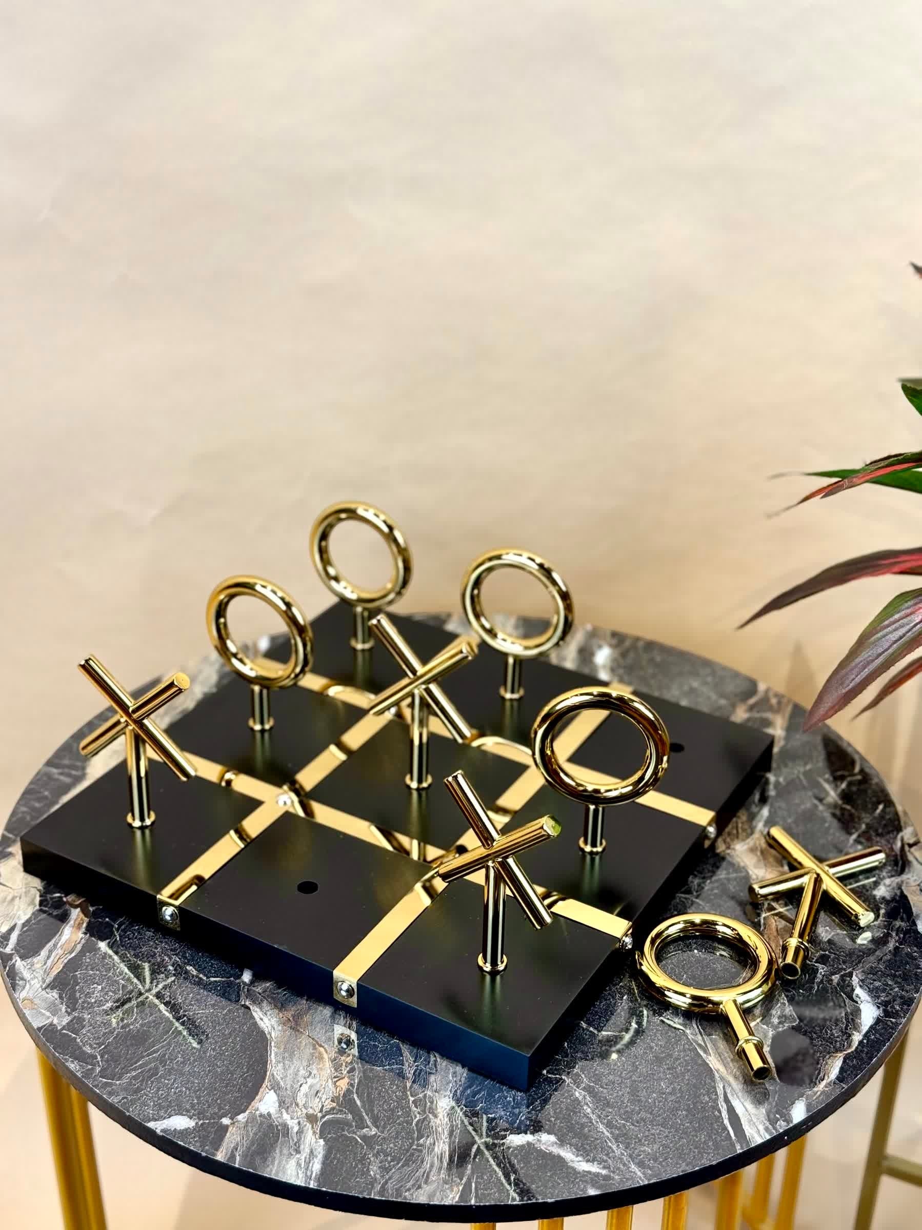 High Objects Sculpted Gold Tic-Tac-Toe Set with black MDF board and gold-finished iron X and O pieces.