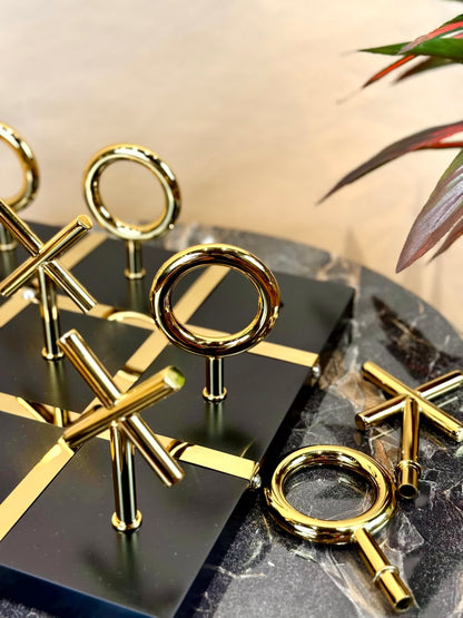 High Objects Sculpted Gold Tic-Tac-Toe Set with gold-finished iron X and O pieces on a black MDF board.