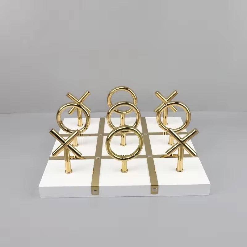 High Objects Sculpted Gold Tic-Tac-Toe Set with gold X and O pieces on a white MDF board with gold accents.