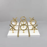 High Objects Sculpted Gold Tic-Tac-Toe Set with gold X and O pieces on a white MDF board with gold accents.