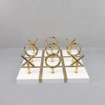 High Objects Sculpted Gold Tic-Tac-Toe Set with gold X and O pieces on a white MDF board with gold accents.