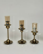 High Objects Seren Column Candle Stand Set, antique brass metal, 3 sizes, amber glass hurricanes, sphere detail, wide base.