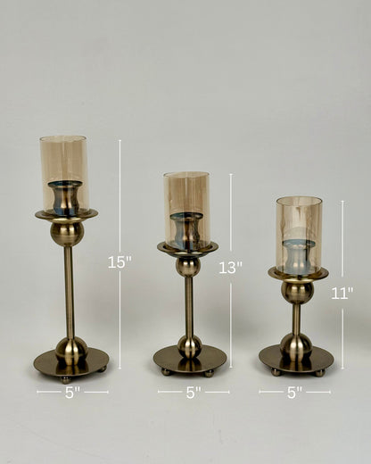 High Objects Seren Column Candle Stand Set, antique brass metal, 3 sizes, amber glass hurricanes, sphere detail, wide base.