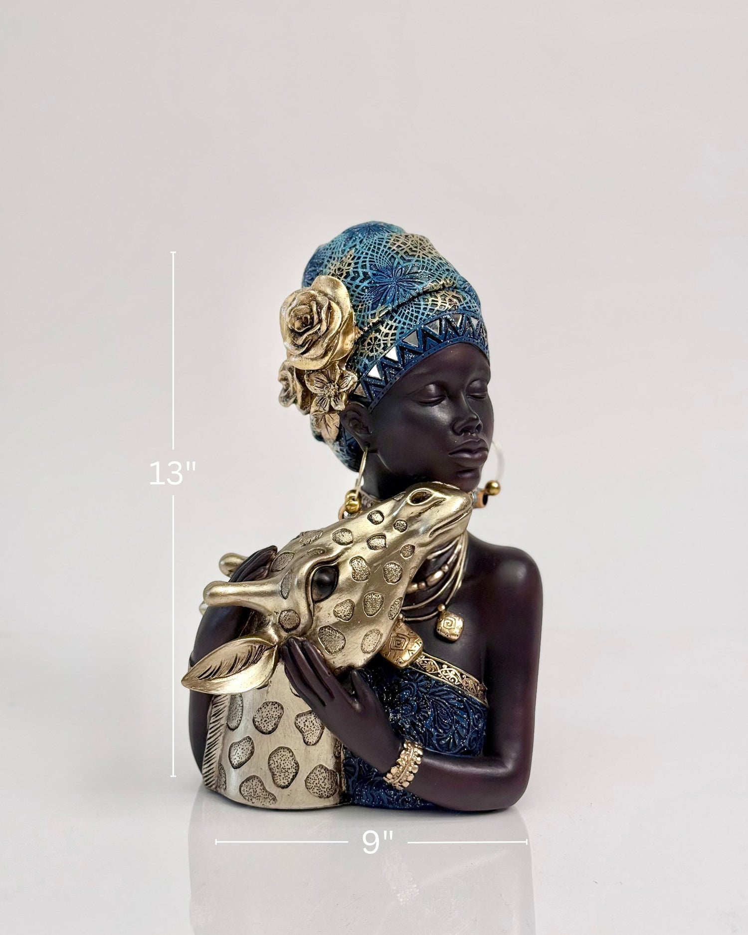 High Objects Serenity Bond Woman &amp; Giraffe Showpiece, a dark-skinned woman in a blue and gold headwrap and dress, embracing a golden giraffe.
