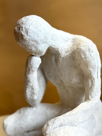 High Objects textured white polyresin showpiece of a faceless figure in a contemplative pose, 10 inches tall.