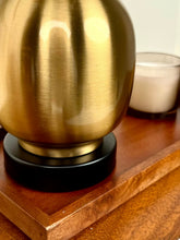 High Objects Solara Sculpted Vase in brushed gold metal with a black base, featuring a rounded body and slender neck.